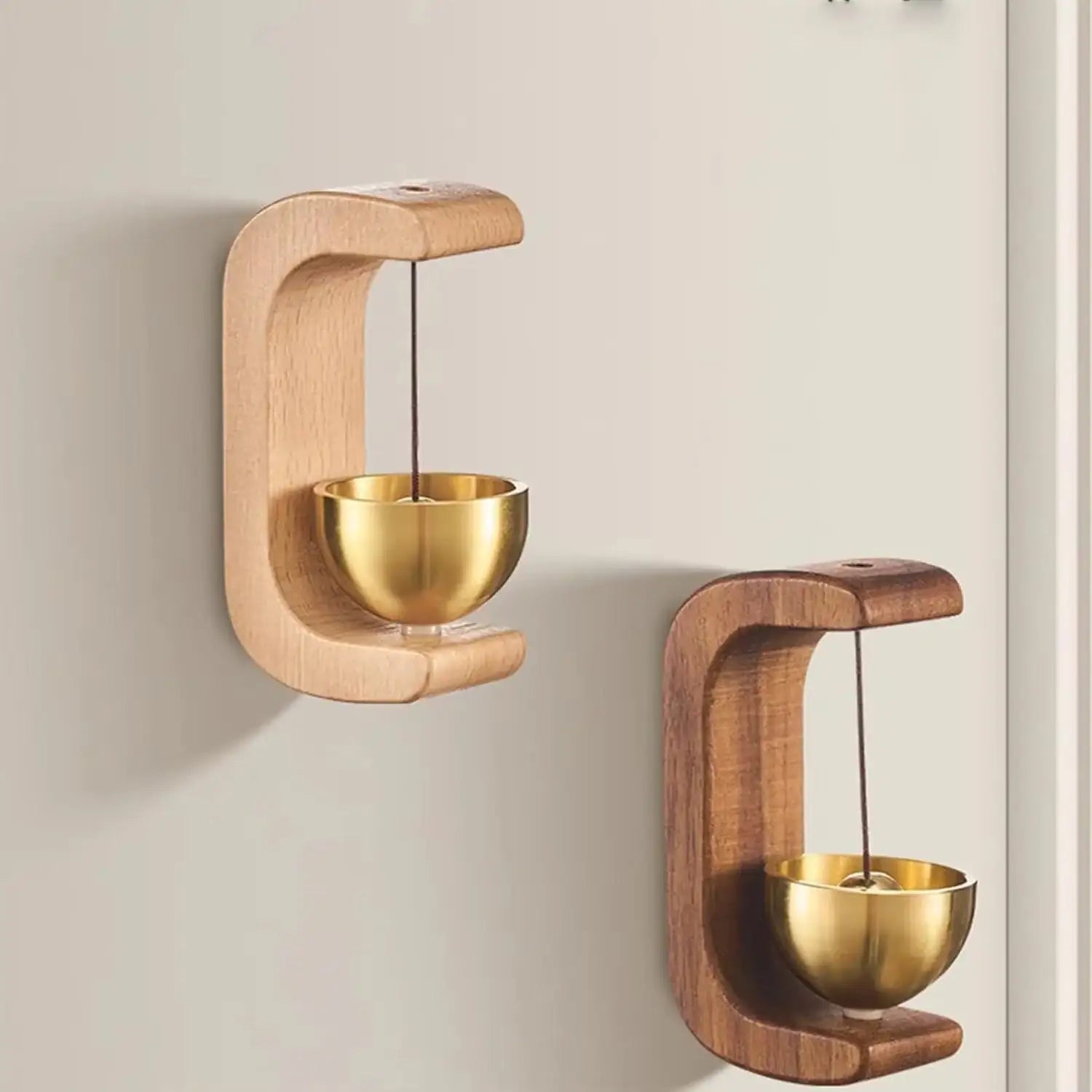 Two wooden wall-mounted candle holders with gold bowls on a beige wall.